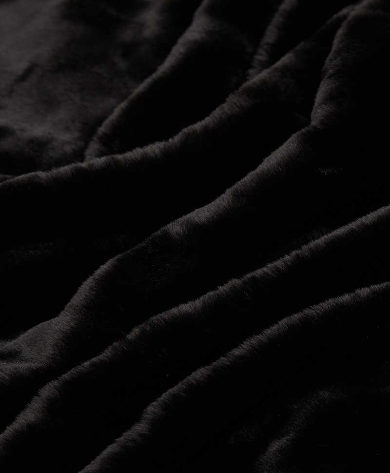 Das Foto zeigt eine Detailaufnahme der Decke Brady aus Kunstfell von der Marke Apparis in der Farbe noir – im Onlineshop RAUM concept store