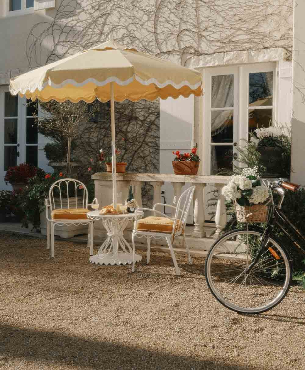 Hier abgebildet ist ein Moodbild des Schirmständerser Clamshell in der Farbe Antique White für die Sonnenschirme von Business & Pleasure aus der Sommerkollektion 2024 im RAUM concept store.