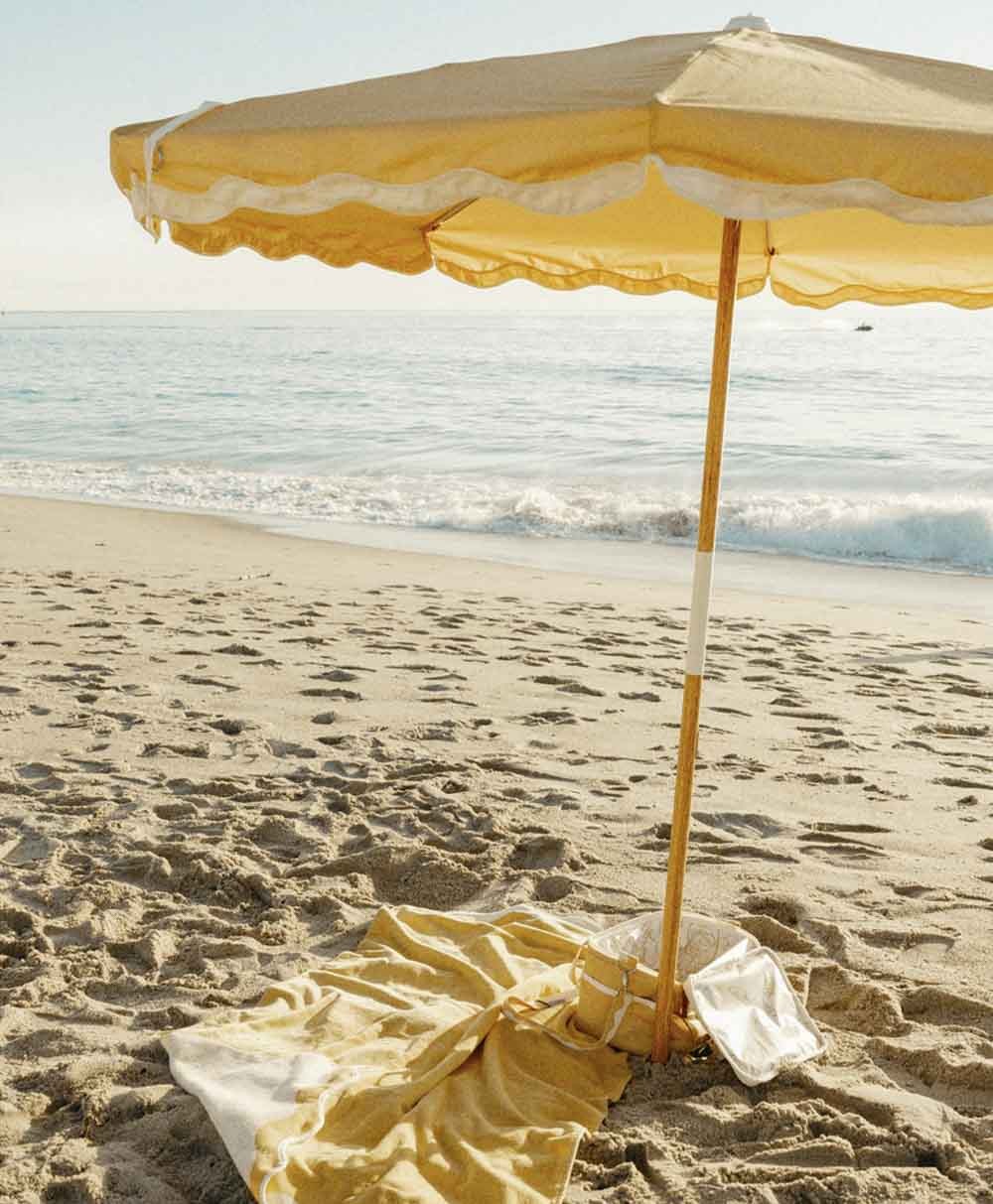 Moodbild des Sonnenschirms Amalfi Beach Umbrella  im Rivie Mimosa Design aus der 2024 Sommer Kollektion von Business & Pleasure im RAUM concept store.
