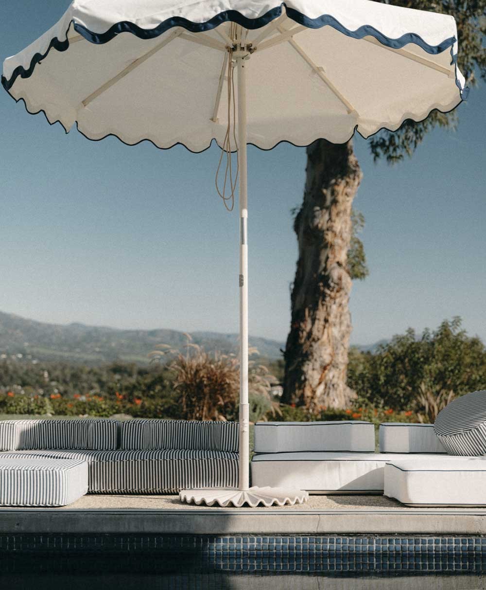 Hier abgebildet ist ein Moodbild des Schirmständerser Clamshell in der Farbe Antique White für die Sonnenschirme von Business & Pleasure aus der Sommerkollektion 2024 im RAUM concept store.