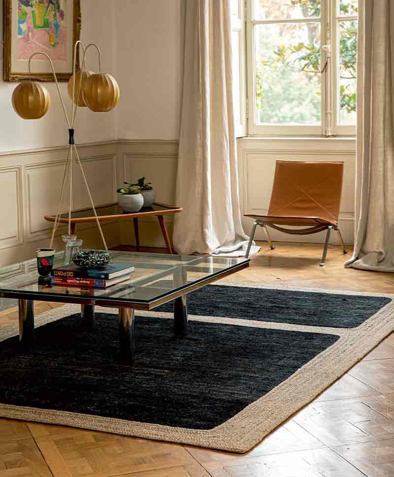 Das Moodbild zeigt den Jute Teppich Jude in der Farbe Graphite von Élitis in einem Wohnbereich – im RAUM concept store