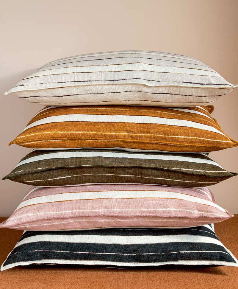 Das Moodbild zeigt die Kissen Stripes auf einem Stapel in den verschiedenen Farbvarianten von Élitis – im Onlineshop RAUM concept store