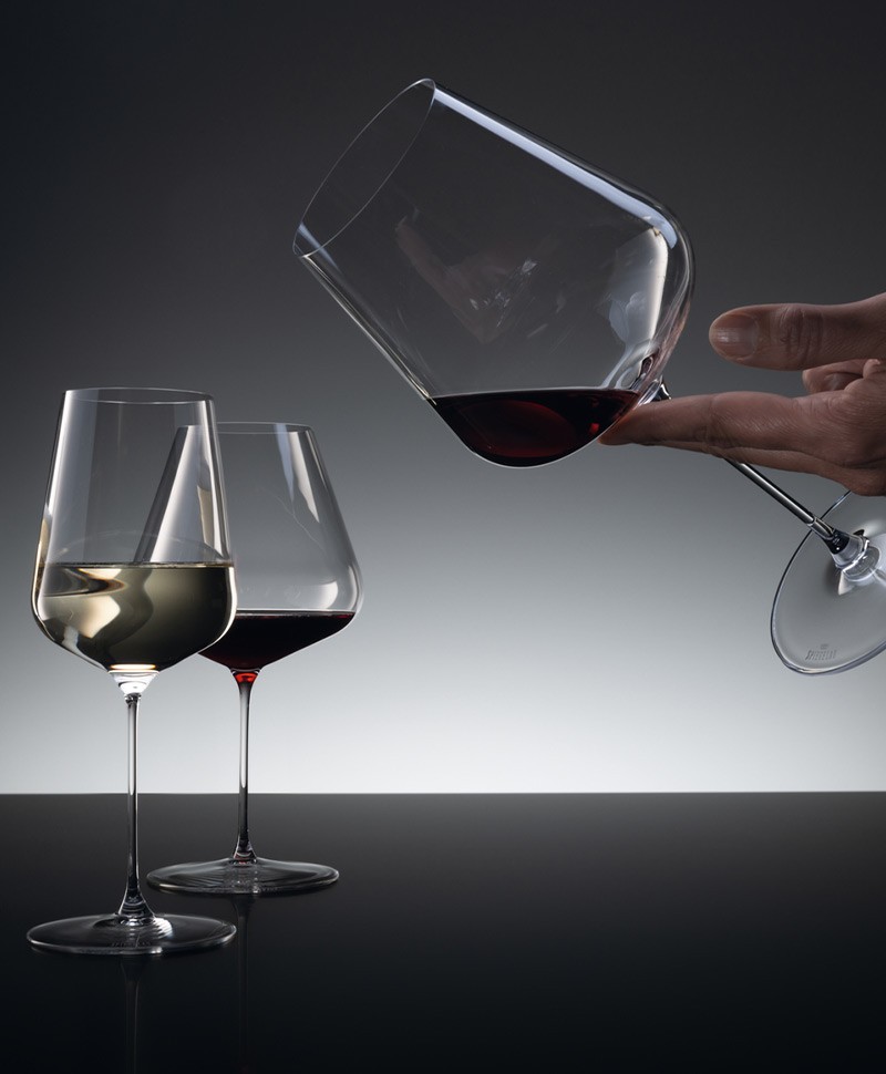 Weißwein- und Rotweingläser vor einem eleganten dunklen Hintergrund