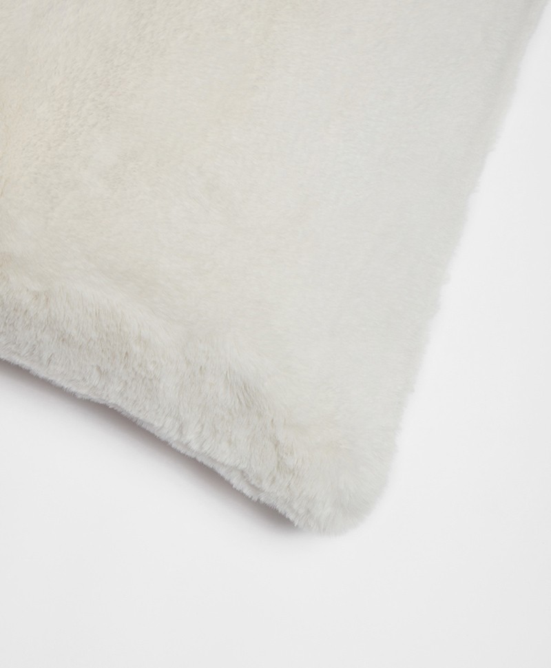 Das Foto zeigt eine Detailaufnahme des Kissen aus Kunstfell von der Marke Apparis in der Farbe ivory – im Onlineshop RAUM concept store