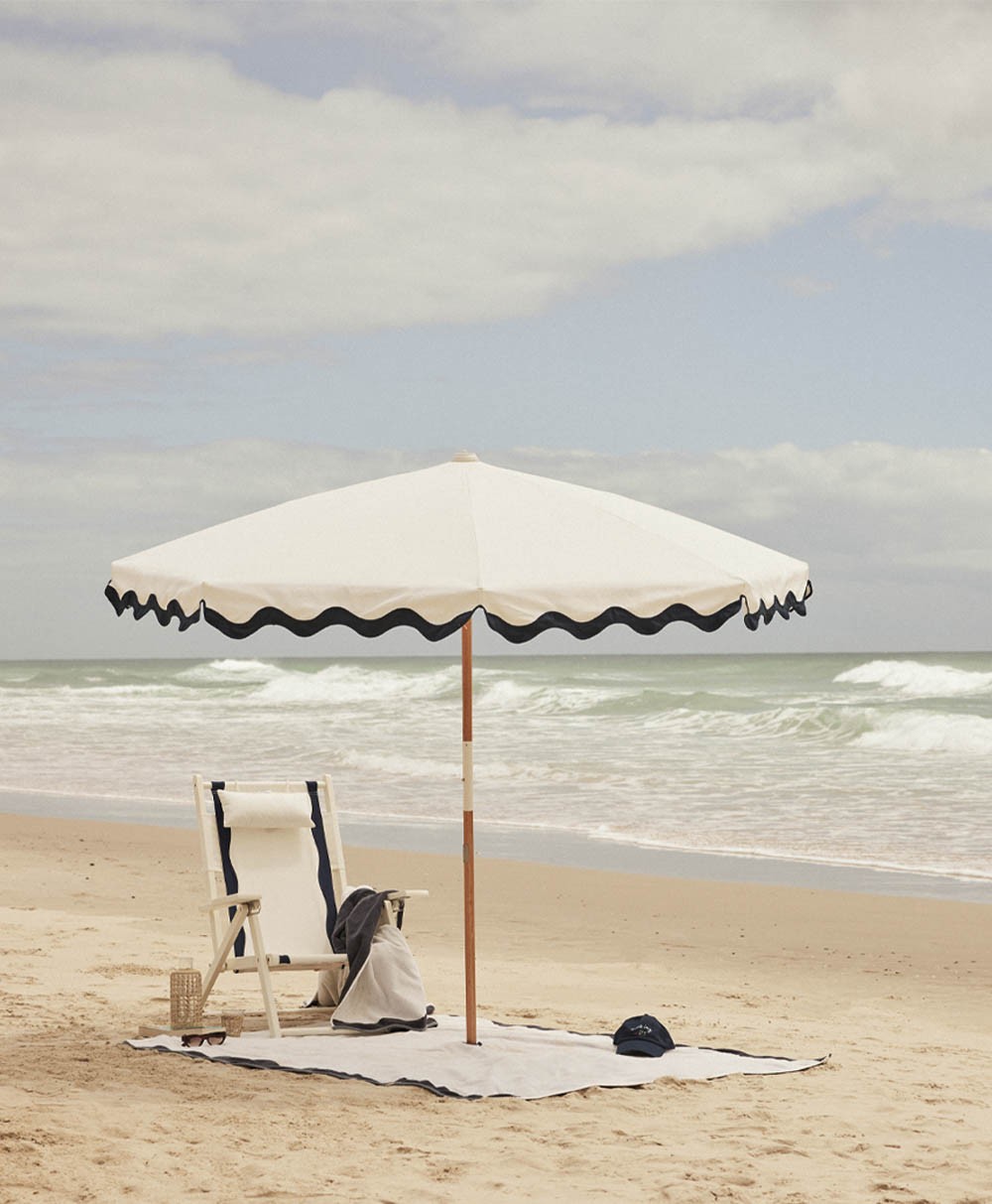 Moodbild des Sonnenschirms Amalfi Beach Umbrella  im Rivie White Design aus der 2024 Sommer Kollektion von Business & Pleasure im RAUM concept store.