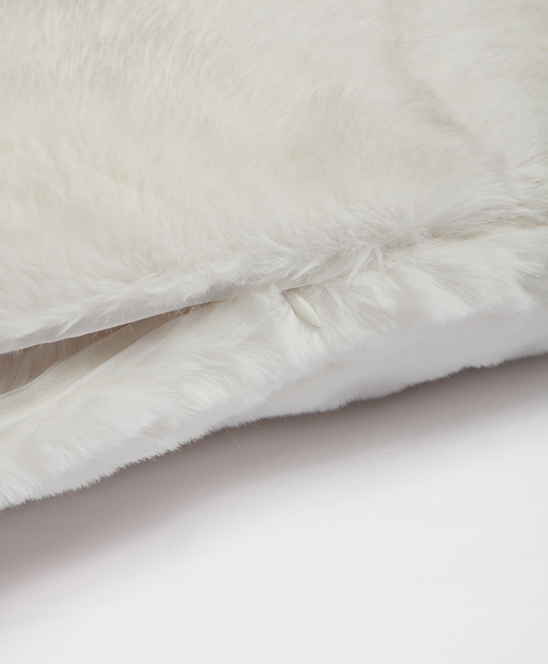 Das Foto zeigt eine Detailaufnahme des Kissen aus Kunstfell von der Marke Apparis in der Farbe ivory – im Onlineshop RAUM concept store