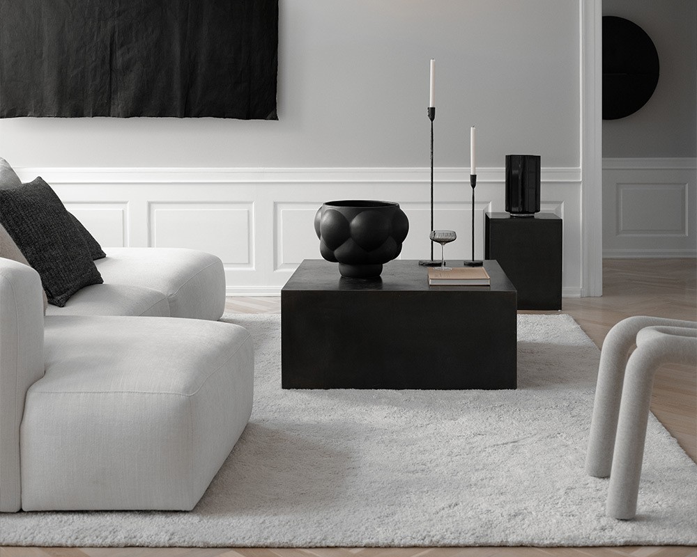 Bannerbild, das ein minimalistisch eingerichtetes Wohnzimmer mit der schwarzen Ballon Bowl von Louise Roe als Herzstück zeigt