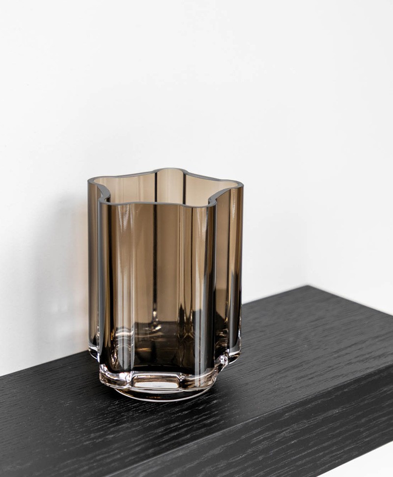 Moodbild, das die Funki Vase in der Farbe smoke von Louise Roe auf einem dunklen Regalbrett zeigt