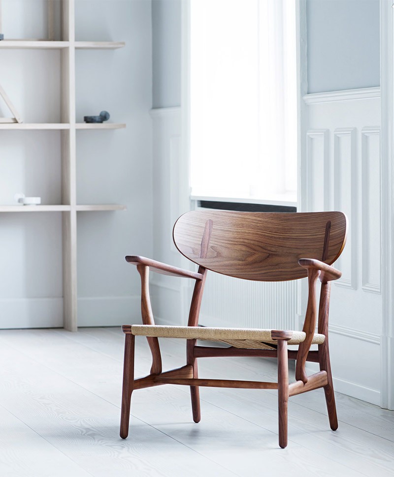 Ein stilvoller Holzstuhl in einem hellen Raum vor einem Fenster