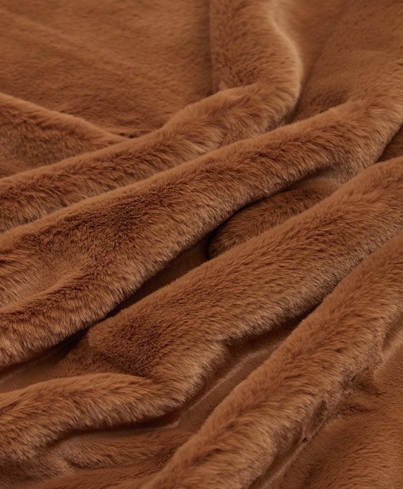 Das Foto zeigt eine Detailaufnahme der Decke Brady aus Kunstfell von der Marke Apparis in der Farbe camel – im Onlineshop RAUM concept store