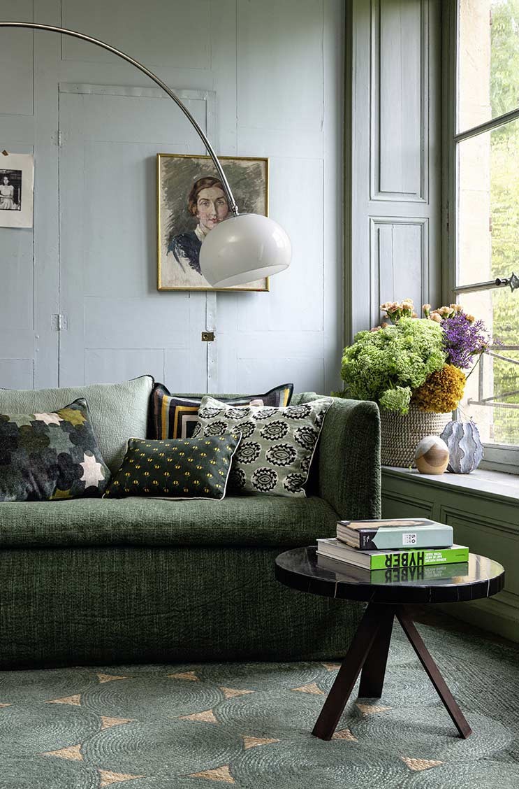 Das Moodbild zeigt Kissen von Élitis auf einem Sofa in einem rustikalen Interior – im RAUM concept store