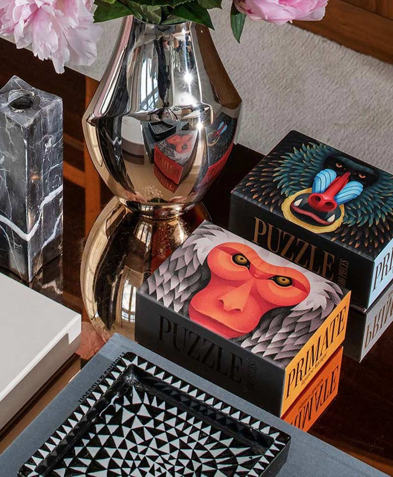 Moodbild, das zwei Puzzle von Printworks neben einer Vase zeigt