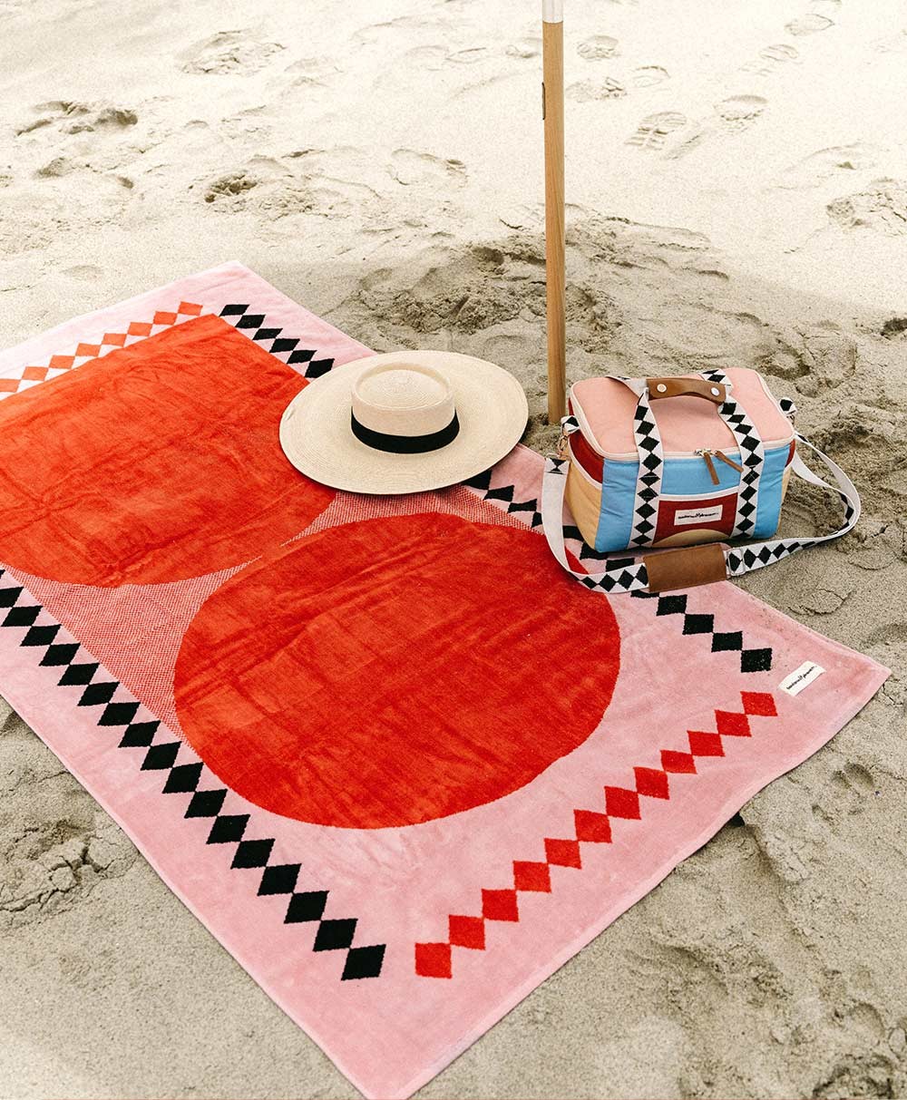 Moodbild des Strandtuchs „Beach Towel“ und der Kühltasche „Premium Cooler“ im pinken Diamond Design aus der 2023 Sommer Kollektion von Business&Pleasure im RAUM concept store.