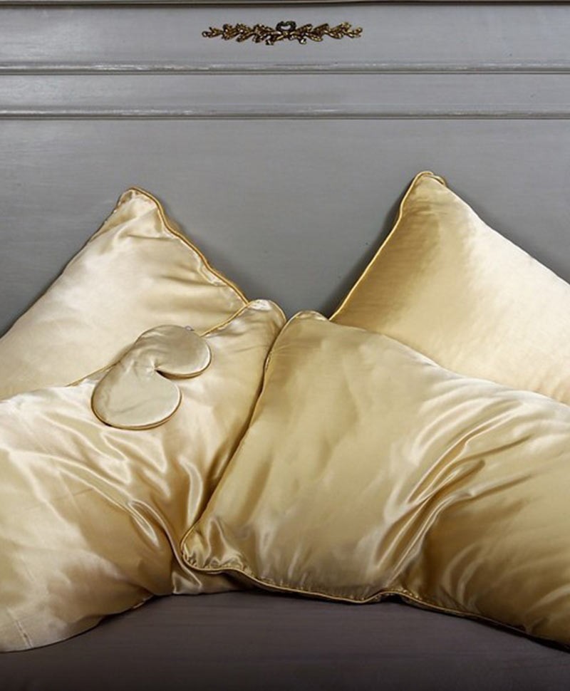 Moodfoto der seidenen Kissenbezüge und der Schlafmaske von Holistic Silk in der Farbe gold