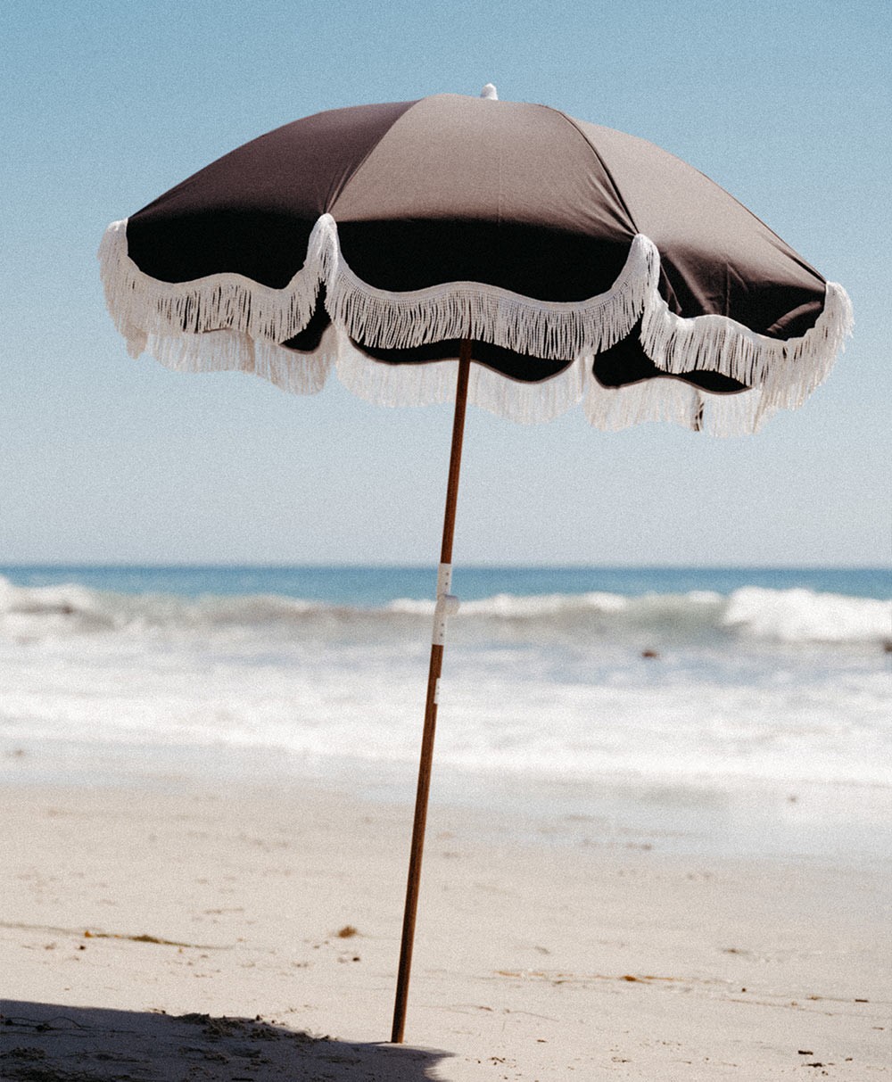 Moodbild des Sonnenschirms „Holiday Beach Umbrella“ im schwarzen Design aus der 2023 Sommer Kollektion von Business&Pleasure im RAUM concept store.