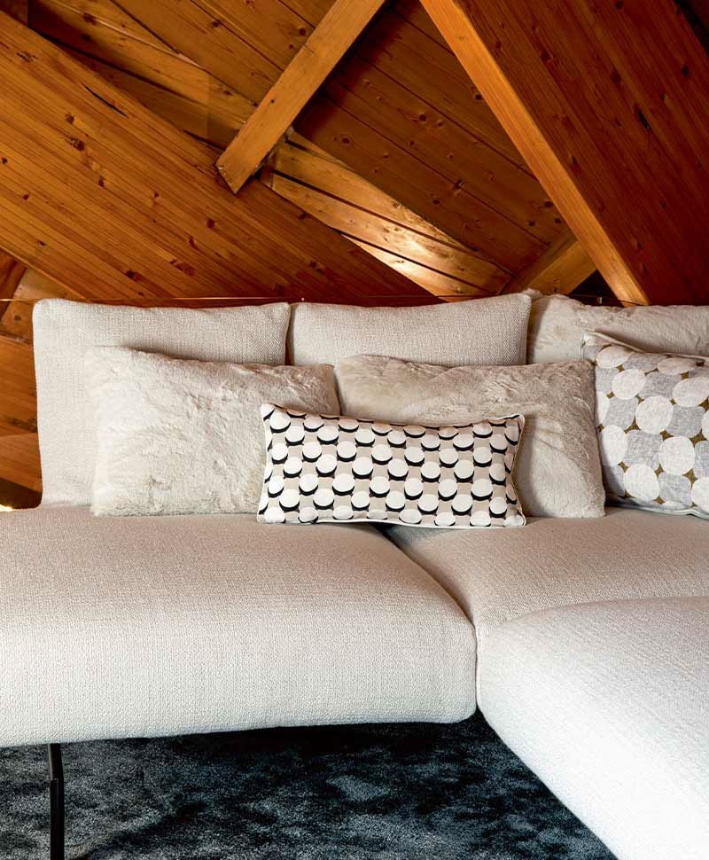 Das Moodbild zeigt verschiedene Kissen in hellen Tönen auf einem Sofa von Élitis – im Onlineshop RAUM concept store