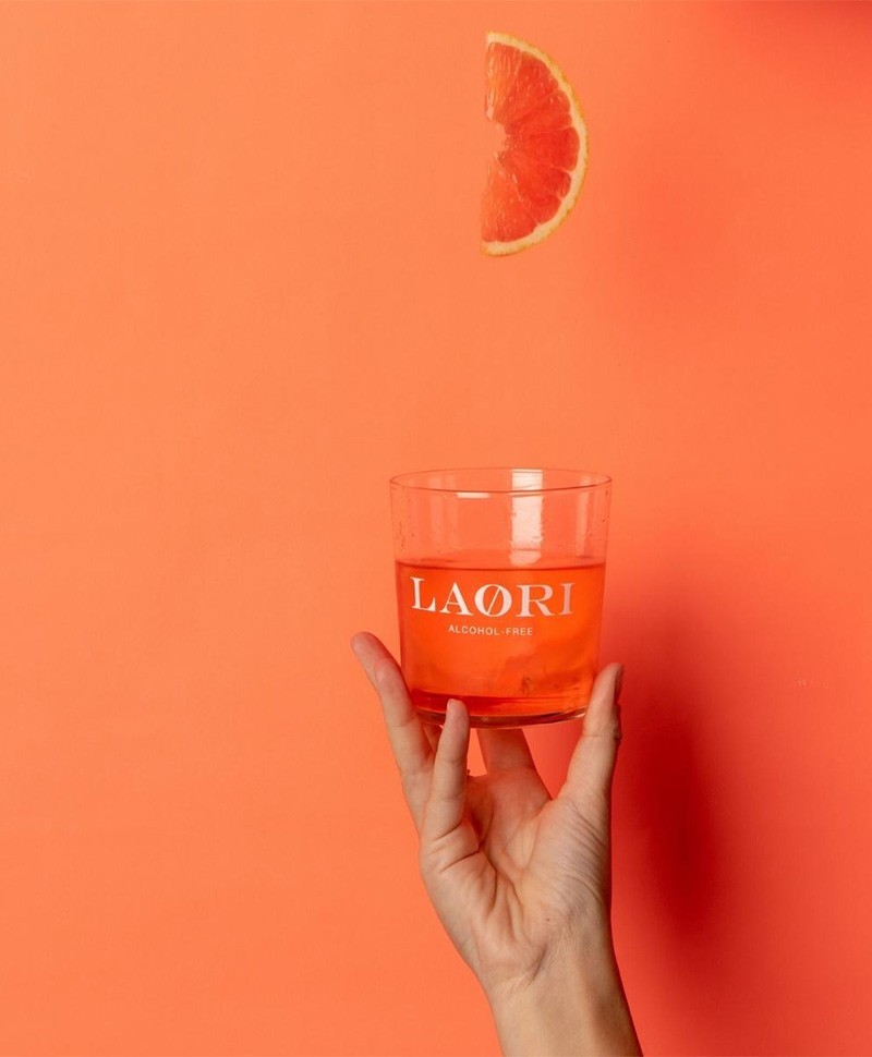 Hier sehen sie ein Glas gefüllt mit alkoholfreiem Aperitif – Ruby No. 4 von der Marke LAØRI und ein Stück Grapefruit – RAUM concept store