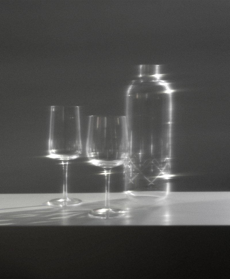 Moodbild, das zwei Weingläser, sowie die Karaffe Chrystal glass von Louise Roe vor einem dunklen Hintergrund zeigt