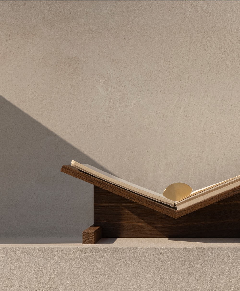 Moodbild des Buchgewichts „Almond“ aus Messing und des Buchständers „Page“ aus Eiche von der Marke CACHÉ im RAUM concept store 