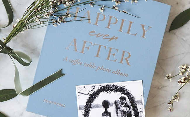 Moodbild des Fotoalbums "Happily ever after" von Printworks, das das Album zusammen mit schwarz-weiß Polaroids einer Hochzeit und dekorativen Trockenblumen zeigt