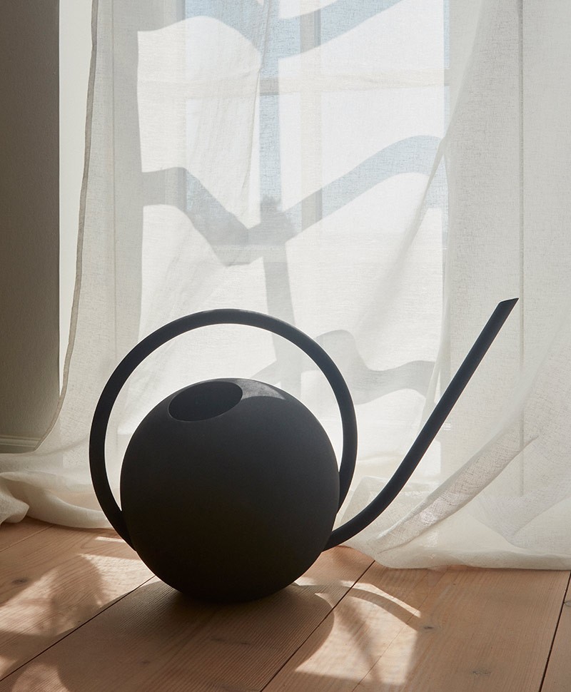 Hier abgebildet ist ein Moodbild der GLOBE Gießkanne von Aytm in Schwarz – im Onlineshop RAUM concept store