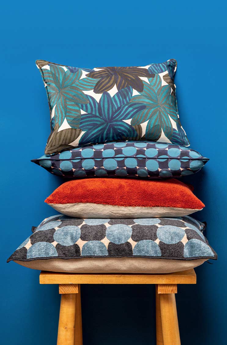 Das Moodbild zeigt einen Stapel von Kissen von Élitis – im Onlineshop RAUM concept store Das Moodbild zeigt einen Stapel von Kissen von Élitis – im Onlineshop RAUM concept store