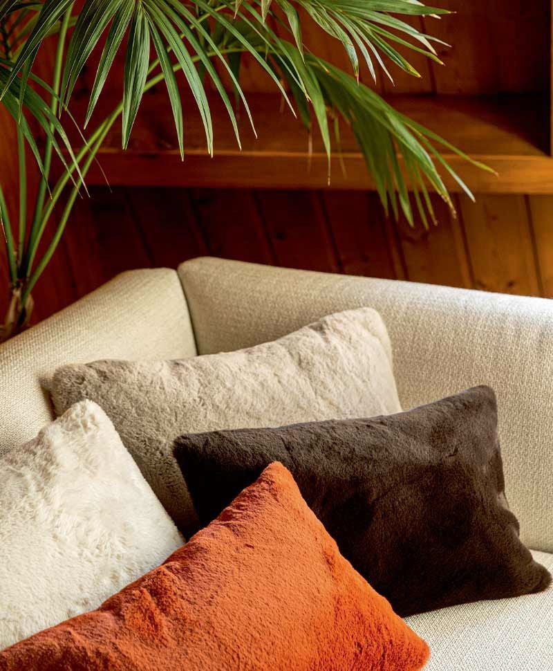 Das Moodbild zeigt die Kissen Winter auf einem Sofa in den verschiedenen Farbvarianten von Élitis – im Onlineshop RAUM concept store