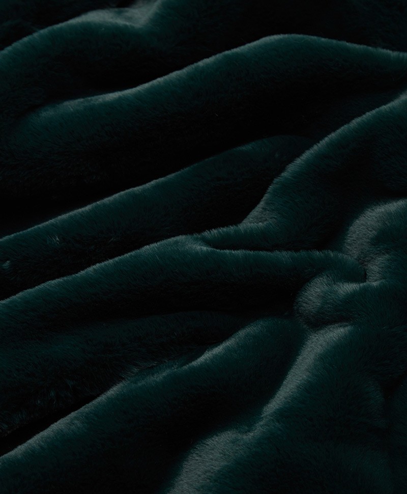 Das Foto zeigt eine Detailaufnahme der Decke Brady aus Kunstfell von der Marke Apparis in der Farbe emerald green – im Onlineshop RAUM concept store